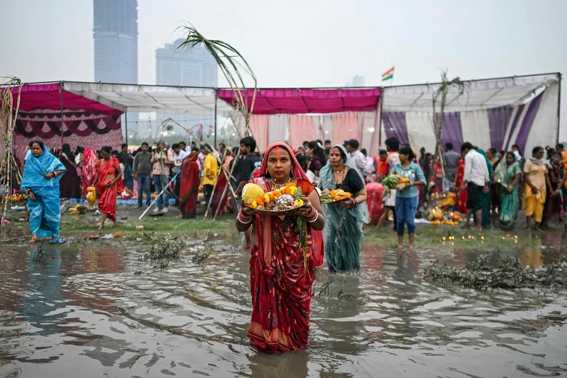 Hindu devotees offering prayers to the sun god Surya in the Yamuna river in New Delhi on Oct 27.