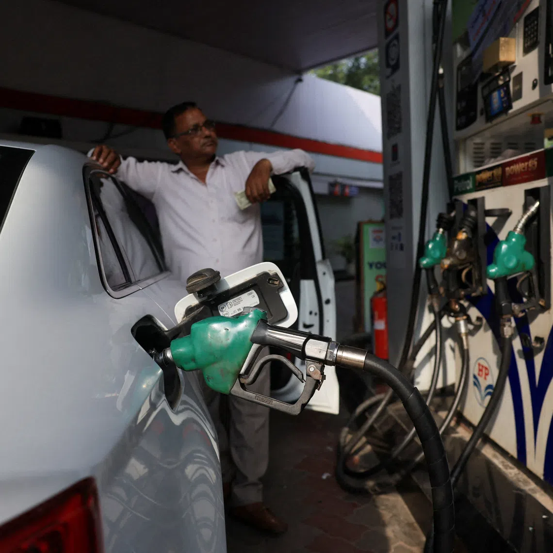 A man checks the fuel dispenser display as his car is being filled with petrol at a fuel station in New Delhi, India, August 3, 2026. REUTERS/Bhawika Chhabra