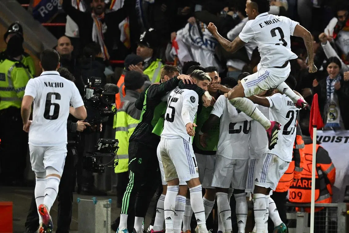 Real Madrid's French forward Karim Benzema is mobbed by teammates after scoring the team's fifth goal.