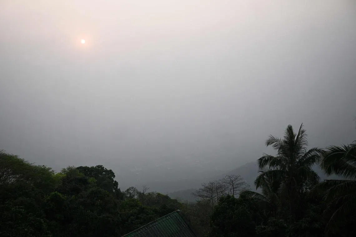 High levels of air pollution obscure the view of Chiang Mai from atop Wat Phra That Doi Suthep temple on March 15, 2024. (Photo by Lillian SUWANRUMPHA / AFP)