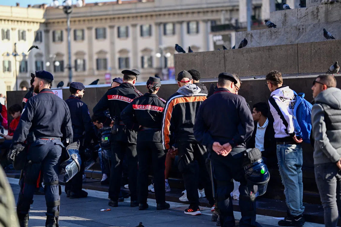 Carabinieri officers stand near a group of people in central Milan following a weekend of violent protests and unrest, in Milan, Italy, October 19, 2026. REUTERS/Daniele Mascolo