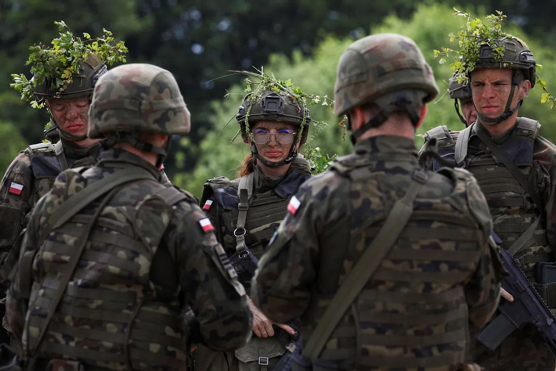 Thirty six-year-old administrator Agnieszka Jedruszak stands with other recruits during voluntary military training at the training ground in Braniewo, Poland, June 24, 2025. REUTERS/Kacper Pempel