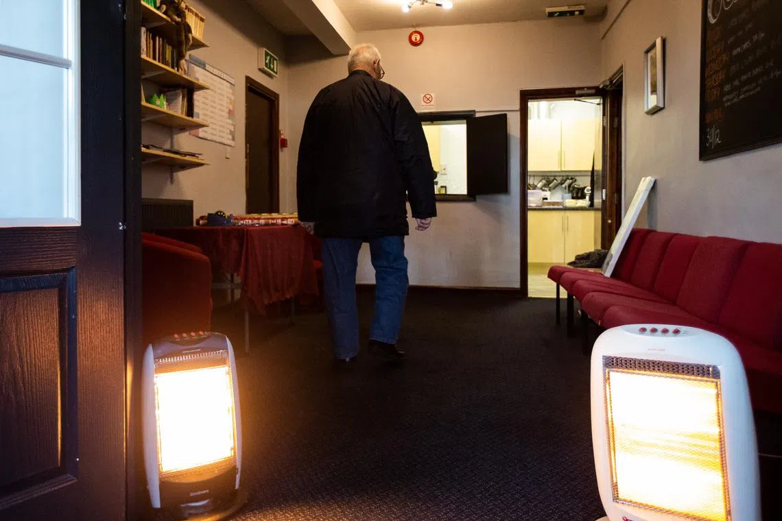 A person walks past electric heaters at the Edge Centre warm bank in Tupton, Britain, on Dec 16 December. 
