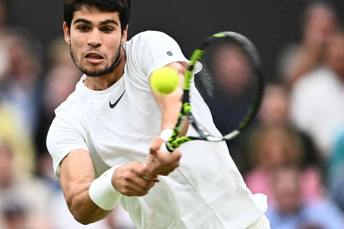 Spain's Carlos Alcaraz returns the ball to Russia's Daniil Medvedev during their men's singles semi-finals tennis match on the twelfth day of the 2023 Wimbledon Championships at The All England Lawn Tennis Club in Wimbledon, southwest London, on July 14, 2023. (Photo by SEBASTIEN BOZON / AFP) / RESTRICTED TO EDITORIAL USE