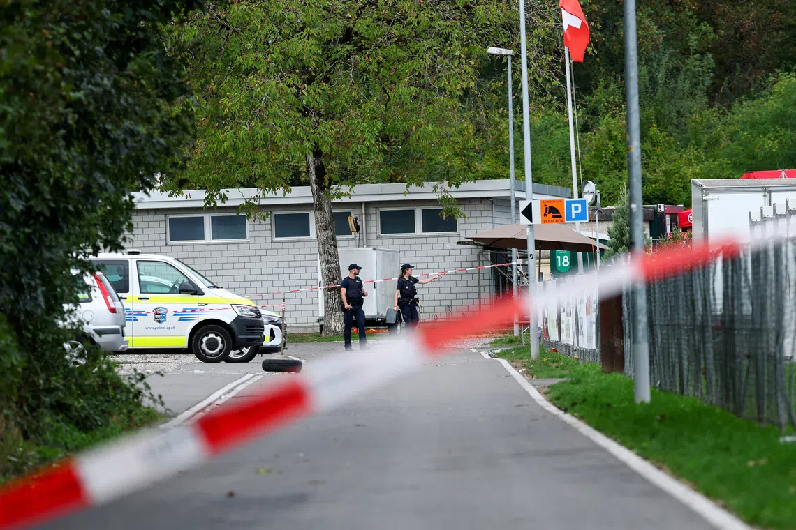 Police officers walk near the site of a rave party, following a deadly shooting incident at an event on Sunday, near the Schachen horse racing track, in Aarau, Switzerland, on Aug 31.