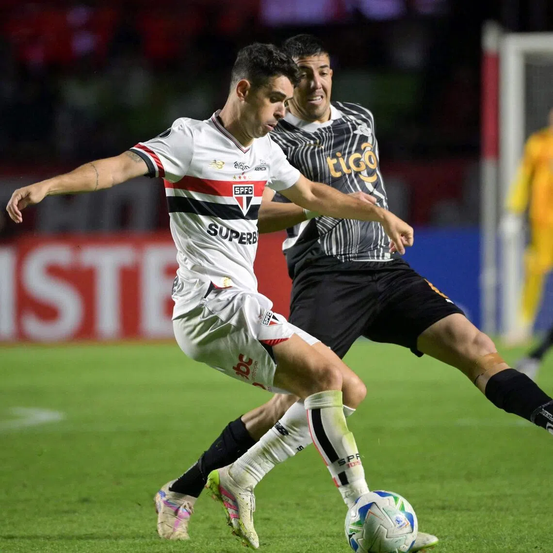 Sao Paulo midfielder Oscar (left) in action against Libertad midfielder Alvaro Campuzano in May 2025, during group stage matches for the Copa Libertadores.