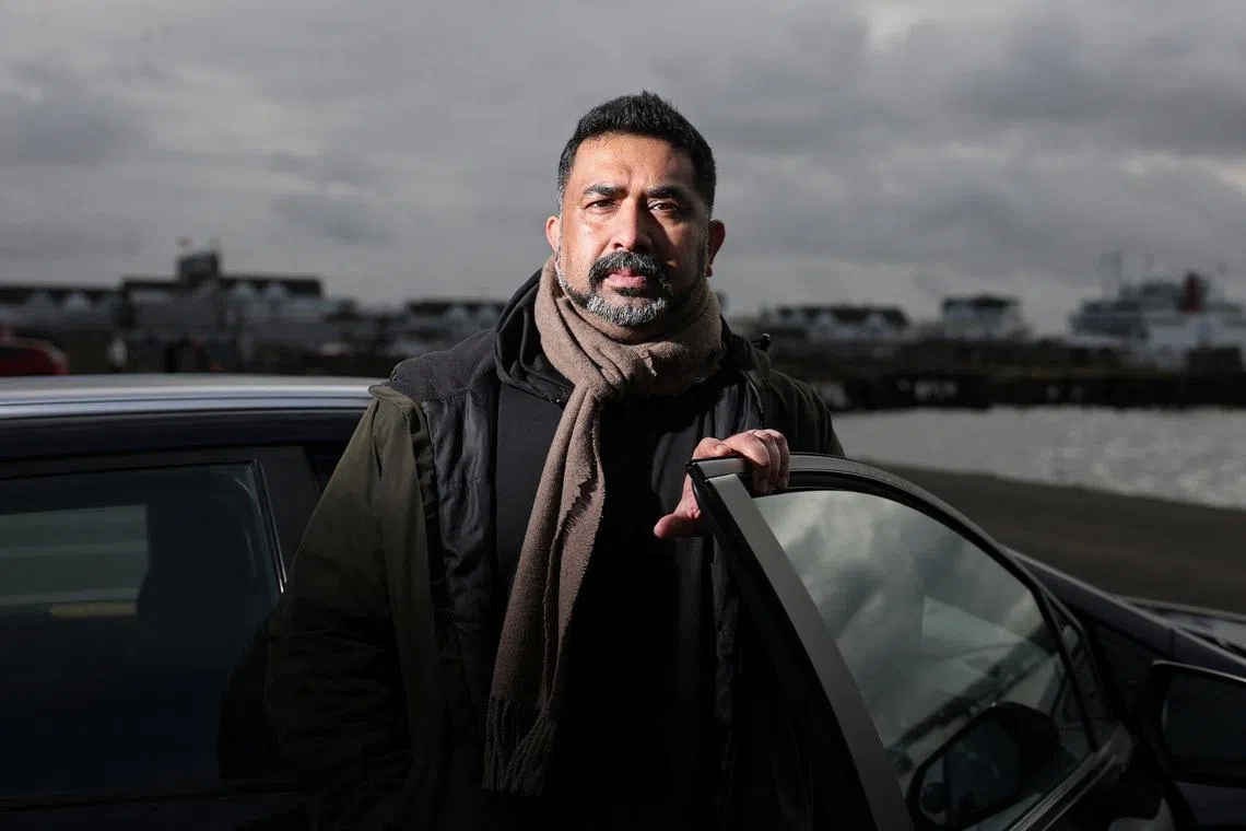 Private hire driver Ali Haydor poses beside his car during an interview with Reuters in Southampton, Britain, February 23, 2026. REUTERS/Toby Melville