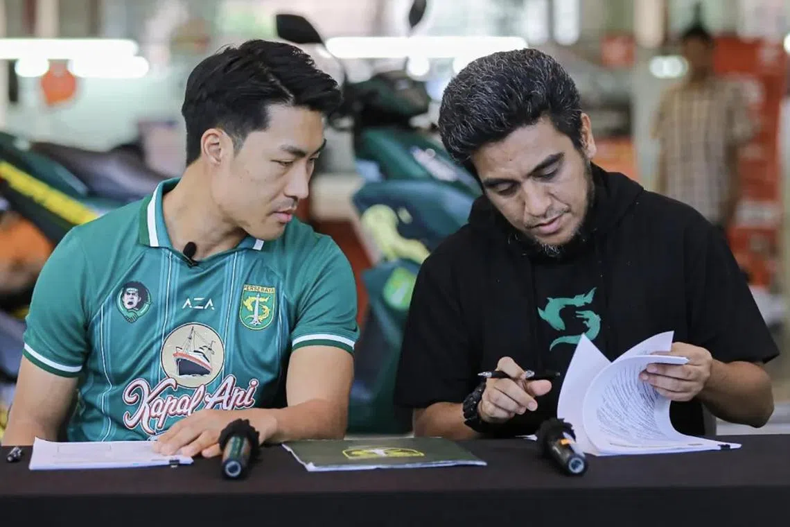 Song Ui-young (left) signing his contract with his new club alongside Persebaya Surabaya manager Yahya Hasan Alkatiri. 