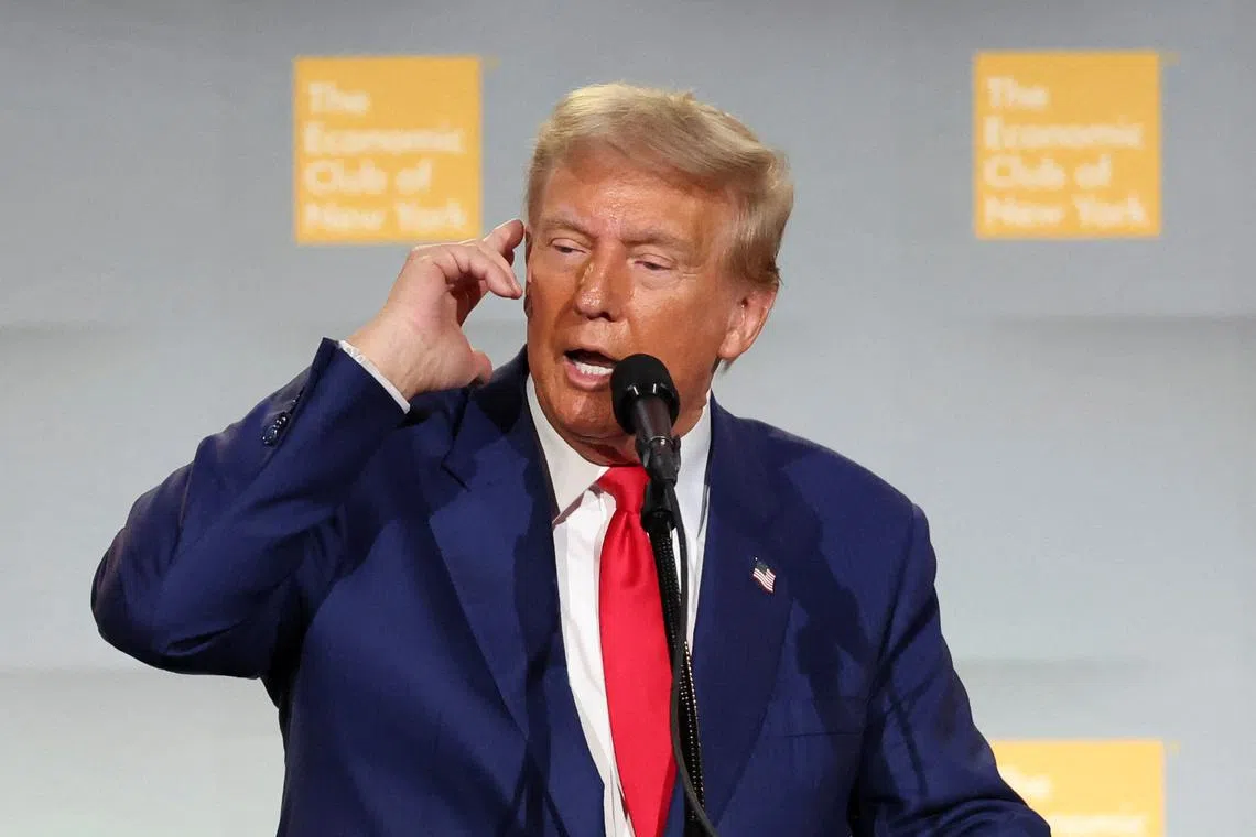Republican presidential nominee and former U.S. President Donald Trump points to his ear as he speaks at the Economic Club of New York in New York City, U.S. September 5, 2024.  REUTERS/Brendan McDermid