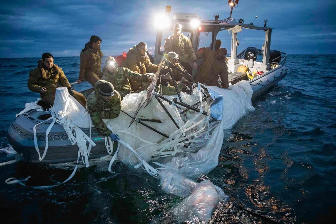 TOPSHOT - This picture provided by the US Navy shows sailors assigned to Explosive Ordnance Disposal Group 2 recover a high-altitude surveillance balloon off the coast of Myrtle Beach, South Carolina, in the Atlantic ocean on February 5, 2023. - US President Joe Biden on February 6, 2023 defended the decision to wait until a Chinese balloon crossed the United States before shooting it down, and the White House said valuable intelligence was being culled from the device. (Photo by Petty Officer 1st Class Tyler Th / US NAVY / AFP) / RESTRICTED TO EDITORIAL USE - MANDATORY CREDIT "AFP PHOTO /  US NAVY" - NO MARKETING NO ADVERTISING CAMPAIGNS - DISTRIBUTED AS A SERVICE TO CLIENTS