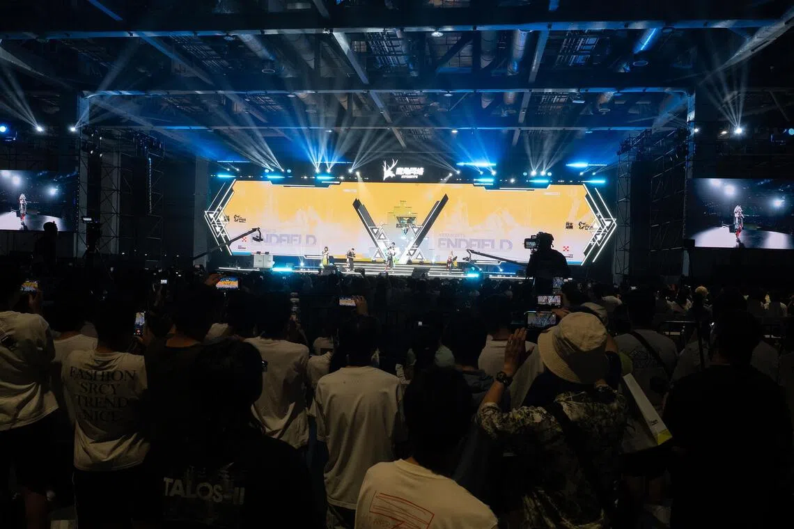 Official cosplayers perform on stage before a large crowd of attendees during the Hypergryph Carnival at the National Exhibition and Convention Center in Shanghai.