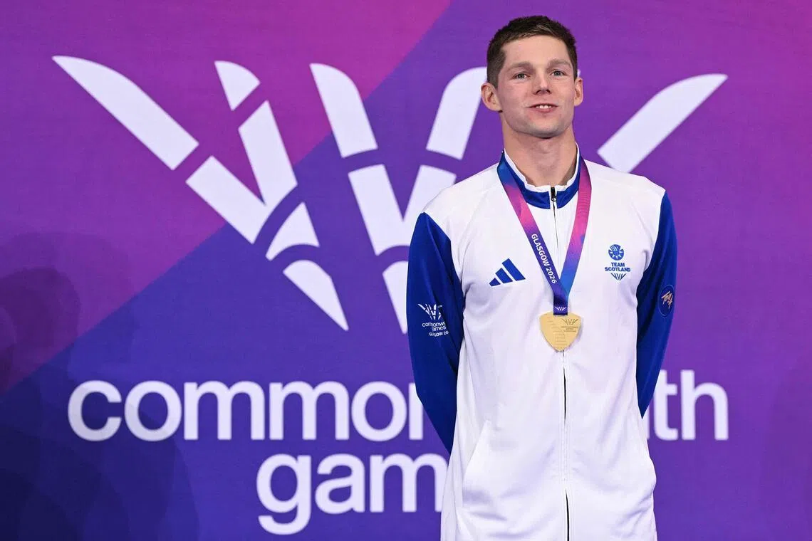 Scotland's Duncan Scott celebrates with his gold medal during the Men's 200m Individual Medley Medal Ceremony at the swimming event at the Tollcross International Swimming Centre in Glasgow, on day one of the Commonwealth Games in Glasgow, Scotland, on July 24, 2026. (Photo by Oli SCARFF / AFP)