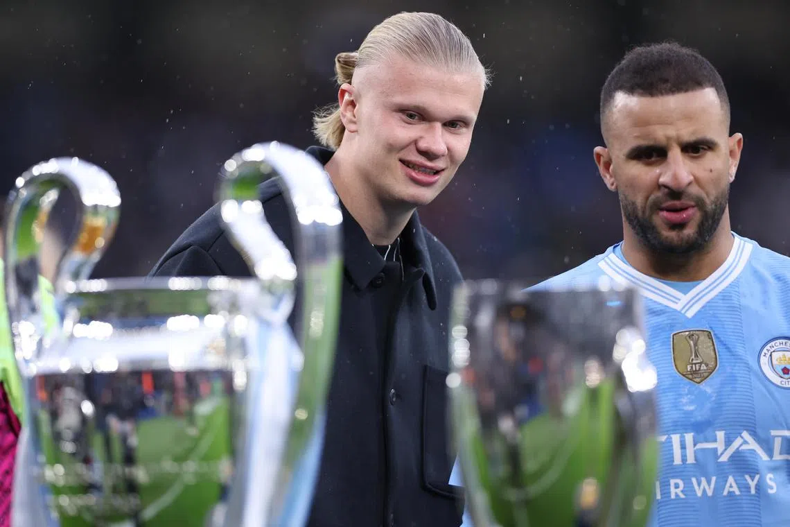 Manchester City's Erling Haaland (left) and Kyle Walker look at trophies on display ahead of  City's Premier League match against Sheffield United.