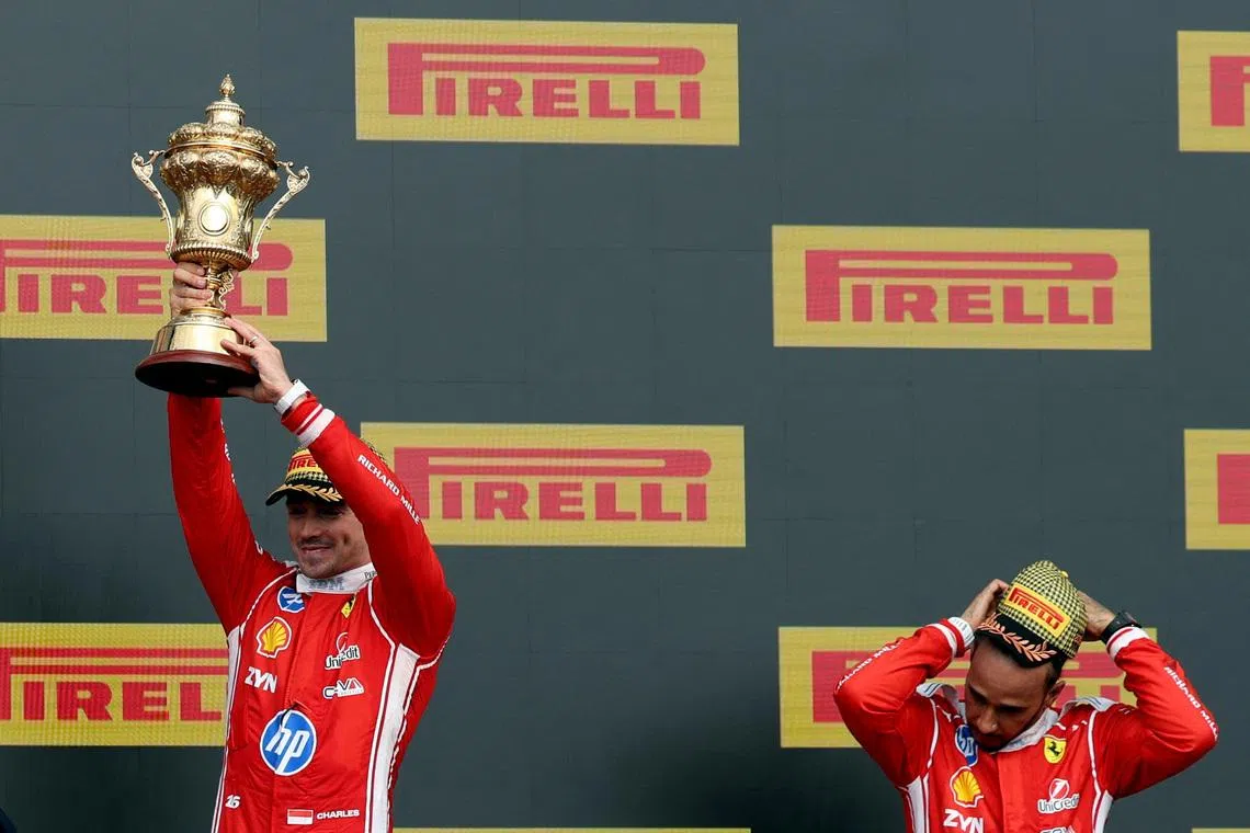 Formula One F1 - British Grand Prix - Silverstone Circuit, Silverstone, Britain - July 5, 2026 Ferrari's Charles Leclerc celebrates with his trophy on the podium after winning the British Grand Prix along with third placed Ferrari's Lewis Hamilton REUTERS/Andrew Boyers