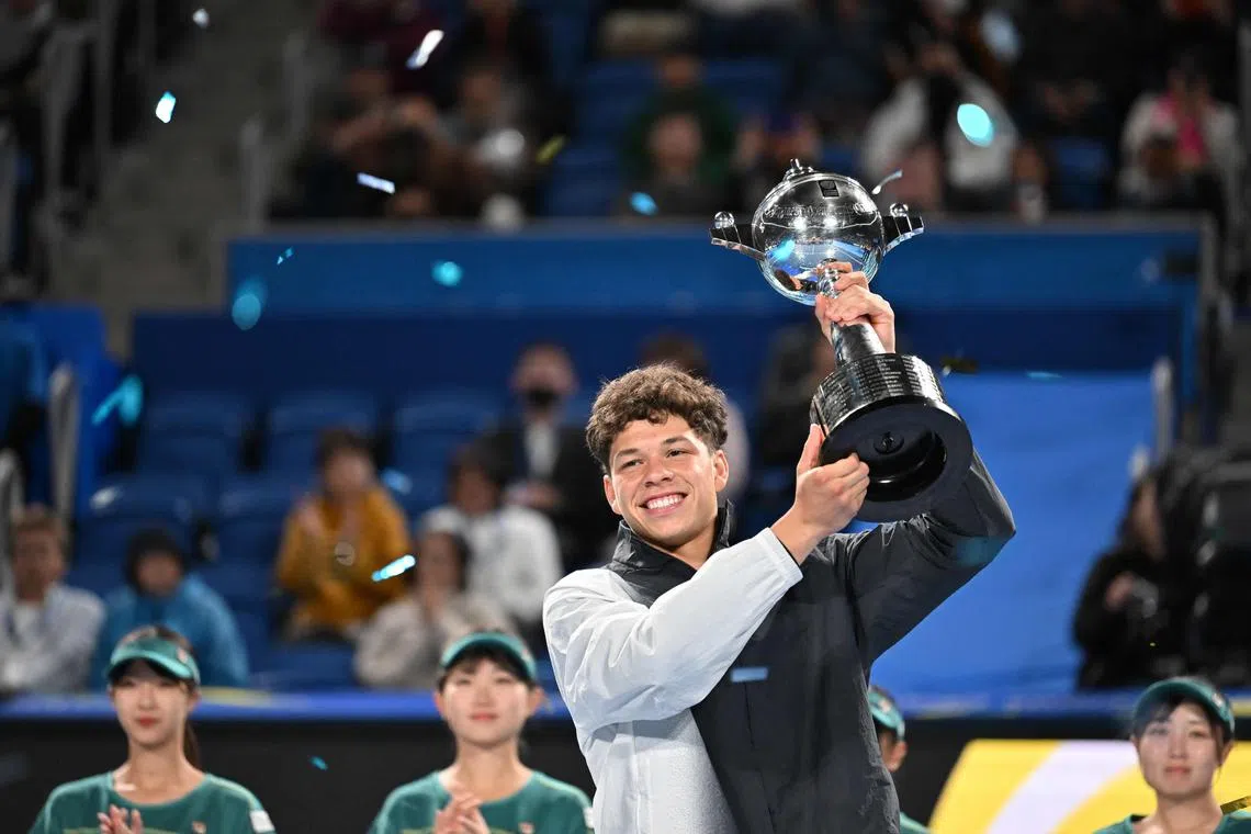 Ben Shelton holds the champion's trophy after beating Aslan Karatsev in the final of the Japan Open.