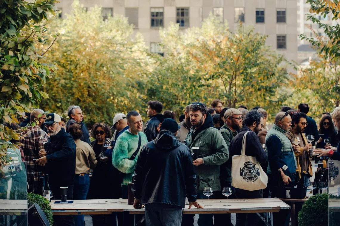 Jean Touitou pours his wine for people at the Karakterre Wine Fair at Rockefeller Center in New York on Nov. 2, 2024. Touitou, the creator of APC, knows how to make something perfectly minimal. (George Etheredge/The New York Times)