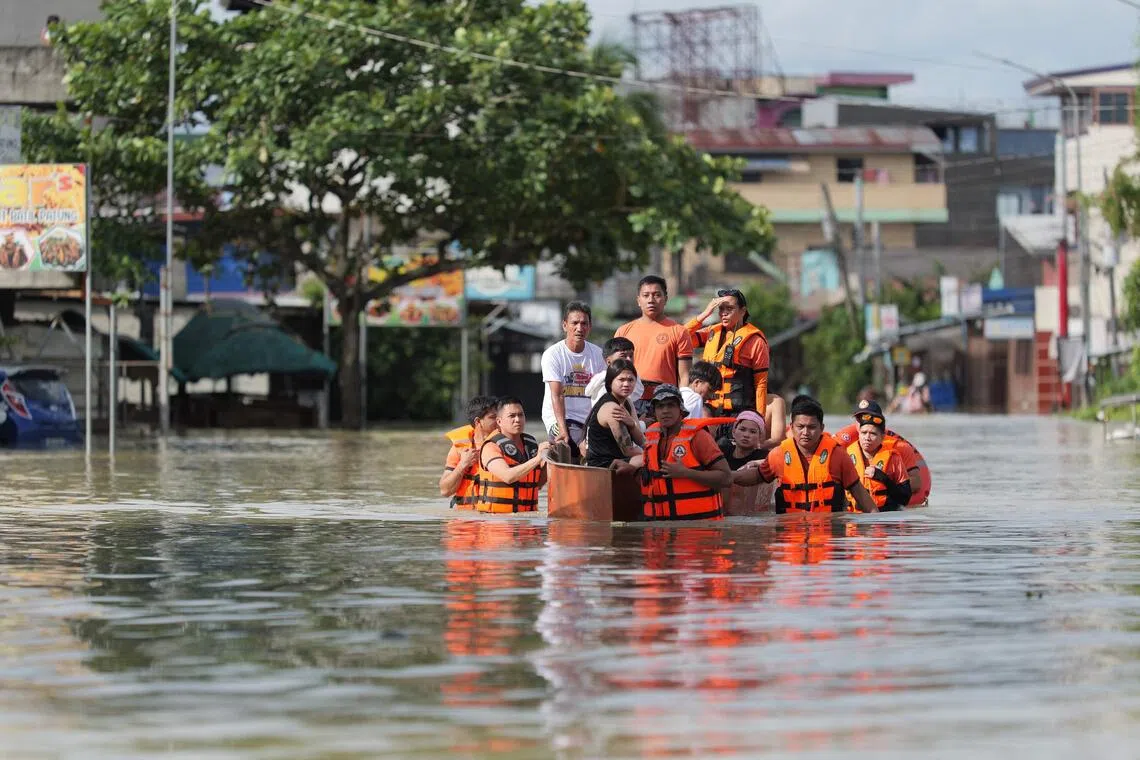 Rescuers pull an inflatable boat loaded with residents during a forced evacuation at a village in Tuguegarao City, Cagayan province, north of Manila on November 11, 2025, as flood waters continue to inundate homes due to heavy rains brought about by Super Typhoon Fung-wong. (Photo by John Dimain / AFP)