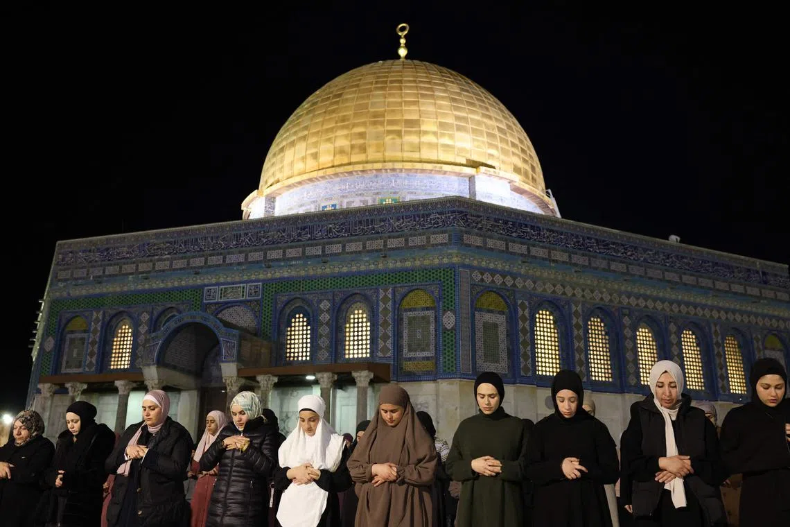 Palestinian Muslim devotees performing an evening prayer known as 'Tarawih' outside the Dome of the Rock in Jerusalem's al-Aqsa Mosque compound during the holy fasting month of Ramadan, on Mar 11, 2024, amid ongoing battles between Israel and the militant group Hamas. 