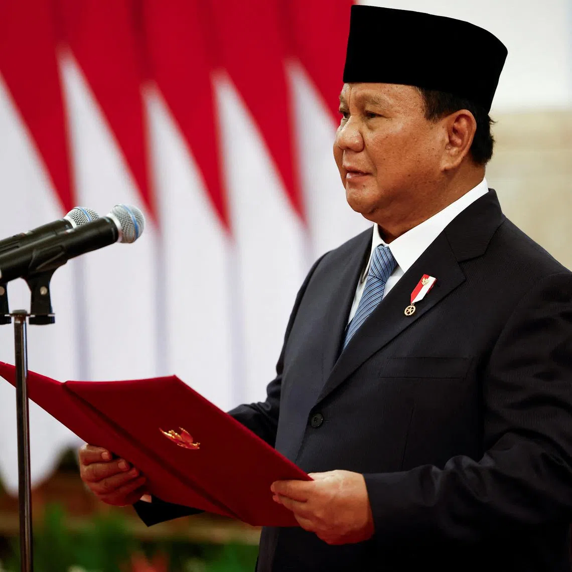 Indonesian President Prabowo Subianto reads out vows, taken by newly appointed ministers during an inauguration at the Presidential palace in Jakarta, October 21, 2024. REUTERS/Willy Kurniawan/File Photo