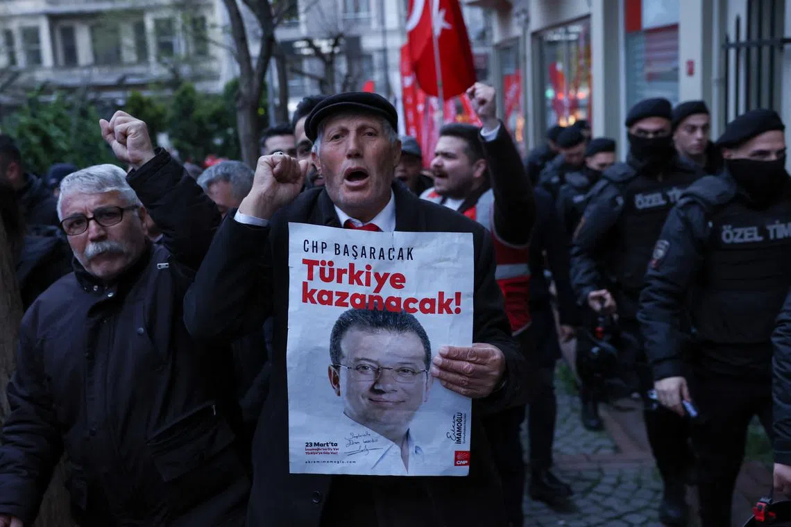 FILE PHOTO: A man holds a poster with a picture of Istanbul Mayor Ekrem Imamoglu during a rally to protest against the arrest of Imamoglu as part of a corruption investigation, in Istanbul, Turkey, April 9, 2025. REUTERS/Dilara Senkaya/File Photo