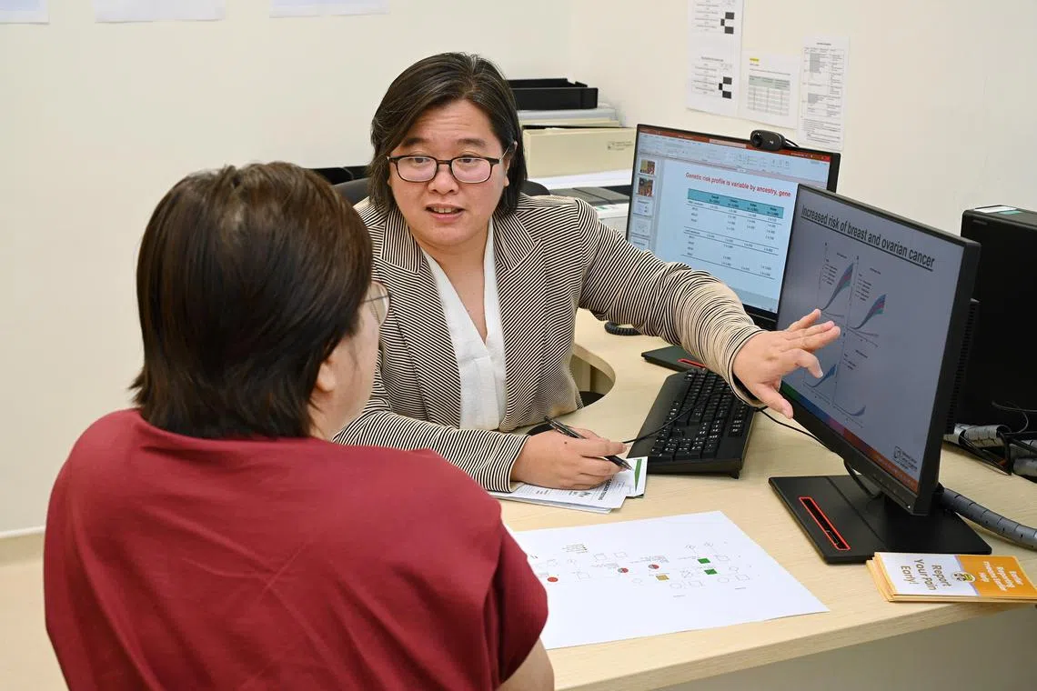 Head of the Cancer Genetics Service at the National Cancer Centre Singapore (NCCS) Joanne Ngeow explaining to patient Elaine Ho, 61, (back to camera) what her BRCA1 gene mutation meant when it comes to familial hereditary. 

