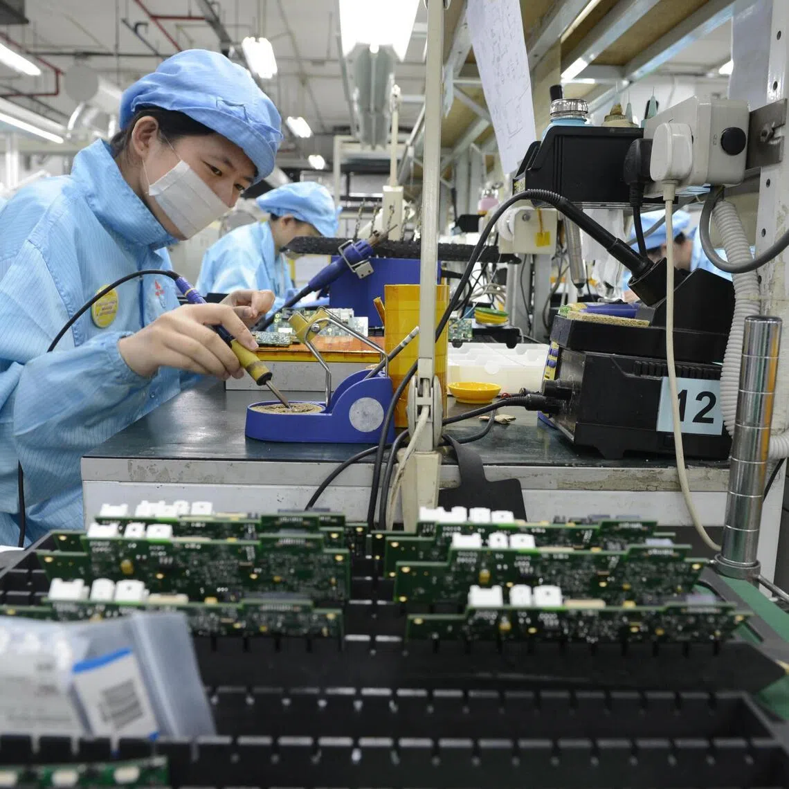 Workers at Add-Plus, an electronics manufacturing company that makes printed circuit boards.