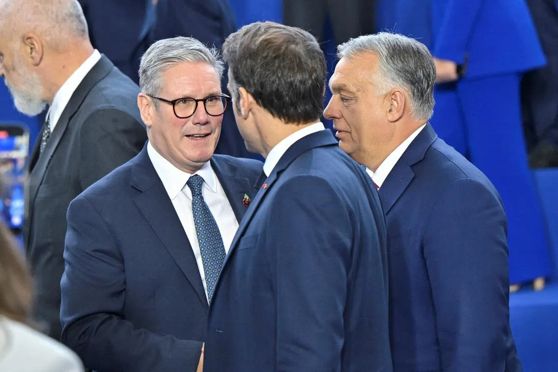 FILE PHOTO: Britain's Prime Minister Keir Starmer, France's President Emmanuel Macron and Hungary's Prime Minister Viktor Orban speak as they gather for a family photo during the European Political Community Summit at the Puskas Arena, in Budapest, Hungary, November 7, 2024. REUTERS/Marton Monus/File Photo