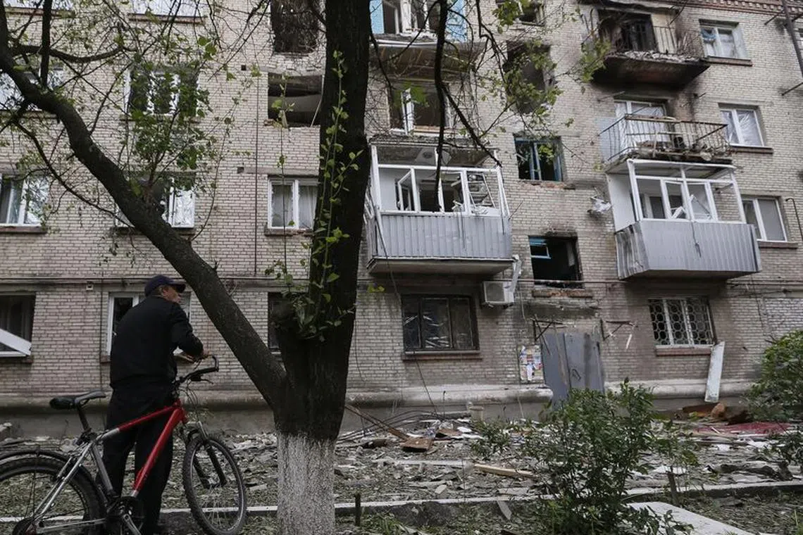 FILE PHOTO: A man looks at a residential building, where he resides, which was damaged by what locals say was overnight shelling by Ukrainian forces, in the eastern Ukrainian town of Slaviansk June 12, 2014. Ukraine's new president signaled on Wednesday he would be ready to hold talks with opponents in eastern Ukraine if pro-Russian separatists waging an insurgency there agreed to lay down their weapons.  REUTERS/Gleb Garanich