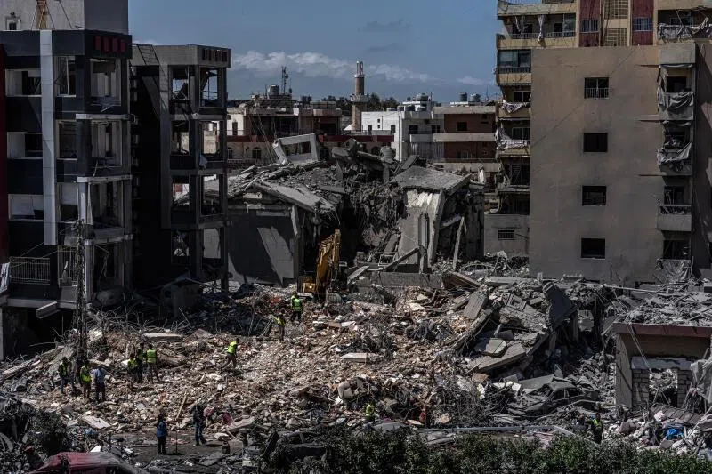 Rescue workers use an excavator as they search for people on June 2, 2026, under the rubble of a building that was hit in an Israeli strike in the southern port city of Tyre.
