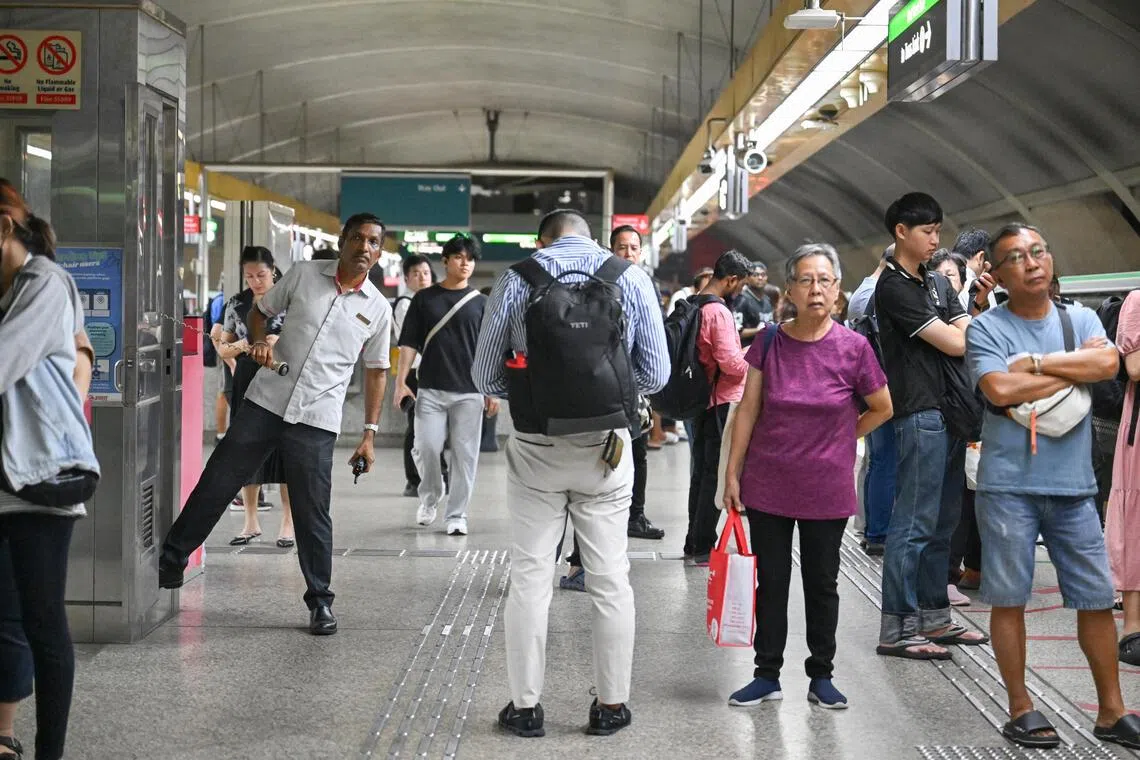 A train staff looking on, and commuters waiting for a train at Kallang MRT station, at 8.39pm, after the announcement of a train fault which had occured, on Dec 2, 2025.