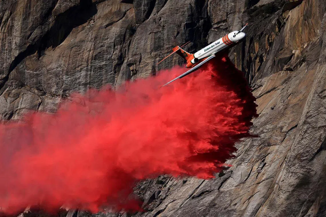 A low-flying tanker dropping fire retardant as the Garnet Fire burns in the Sierra National Forest, California, US,  Aug 26, 2025. 