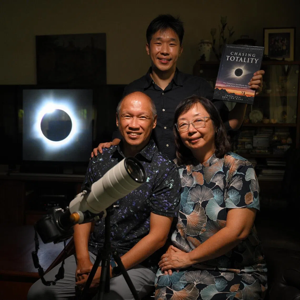 (Clockwise from bottom left) Koh Joo Beng, his wife Janet Tay and their son Jared with a photograph of a total solar eclipse with a “diamond ring” effect, which the elder Koh took in Western Australia in 2023. 