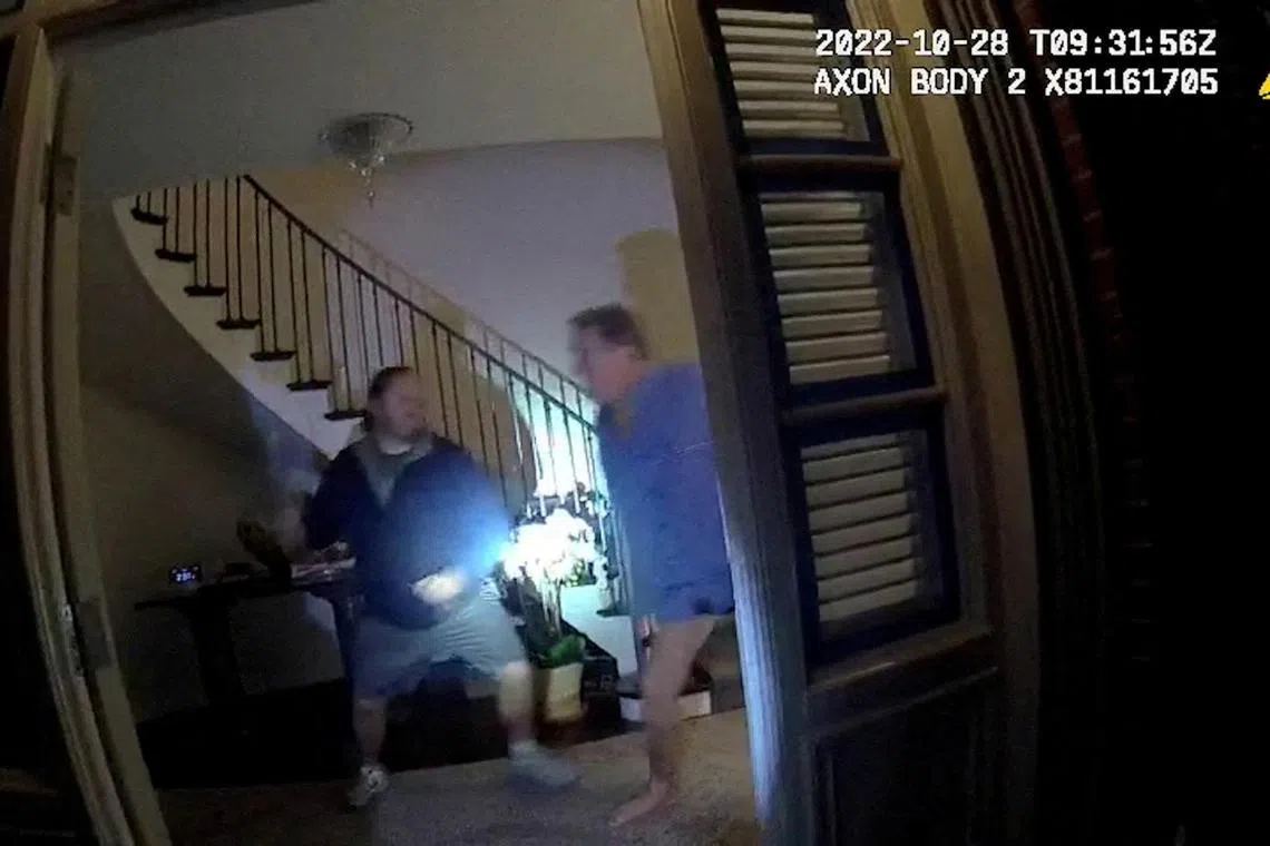 A screenshot from a police body camera video shows David DePape lifting a hammer to strike Paul Pelosi.     