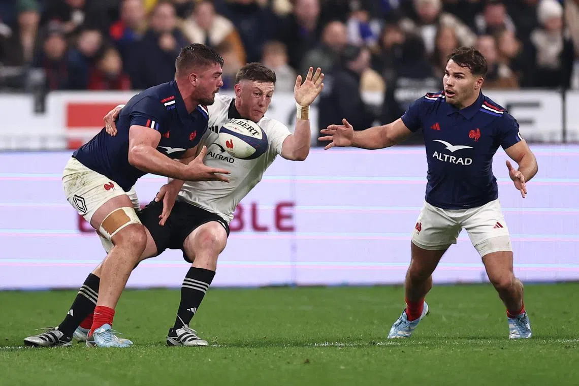 New Zealand's scrum-half Cam Roigard is tackled by France's No. 8 Gregory Alldritt and scrum-half Antoine Dupont.