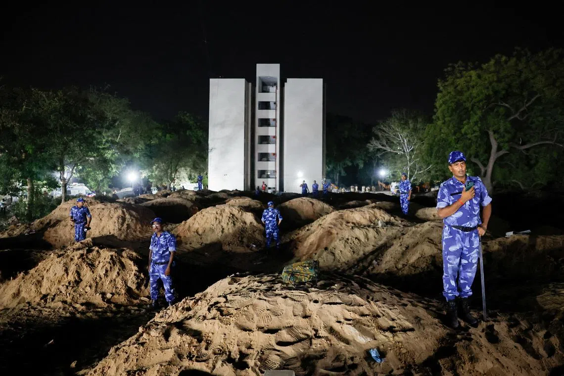 Securit personnel standing at the crash site after an Air India aircraft, bound for London's Gatwick Airport, crashed during take-off from an airport in Ahmedabad, India, on June 12, 2025.