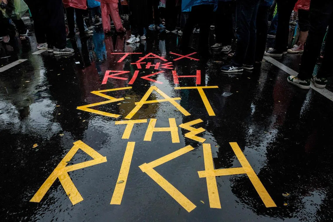 (FILES) Protesters create a sign on a road as they attend a demonstration against President Prabowo Subianto's government, calling for various demands, including reviews of government budget cuts and the free nutritious meal program for schools in front of a police barricade in Jakarta on February 21, 2025. Anger at the quality of life in Southeast Asia's biggest economy -- a nation of 280 million known for pervasive corruption and nepotism -- has stirred student protests and driven young and middle-aged professionals to seek jobs abroad. (Photo by Yasuyoshi Chiba / AFP)