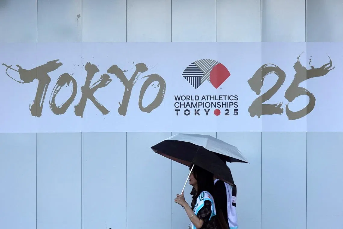 FILE PHOTO: People walk in front of an advertising banner for the upcoming World Athletics Championships Tokyo 25, near the National Stadium in Tokyo, Japan, September 6, 2025. REUTERS/Fabrizio Bensch/File Photo