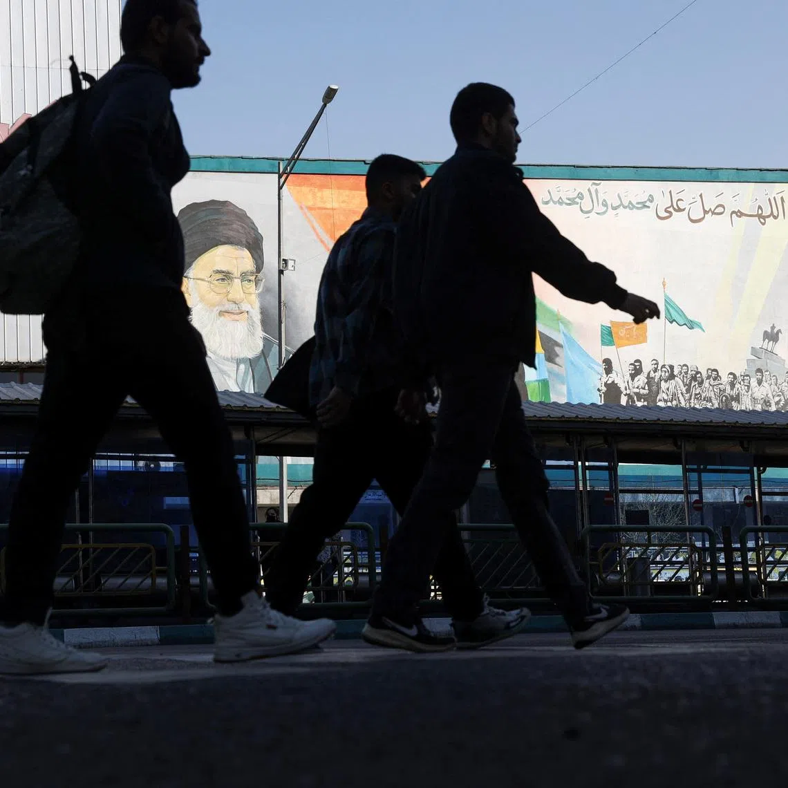 People walk near a mural featuring images of Iran's Supreme Leader Ayatollah Ali Khamenei and the leader of Iran's 1979 Islamic Revolution, Ayatollah Ruhollah Khomeini, on a street in Tehran, Iran, February 26, 2026. Majid Asgaripour/WANA (West Asia News Agency) via REUTERS