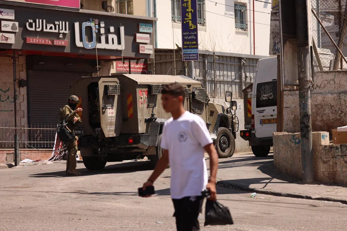 Israeli security forces patrol a street during a military operation in the Qalandia refugee camp, south of the West Bank city of Ramallah, on Aug 6.