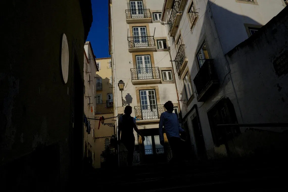FILE PHOTO: People walk in Alfama neighbourhood in Lisbon, Portugal, February 16, 2023. REUTERS/Pedro Nunes/File Photo