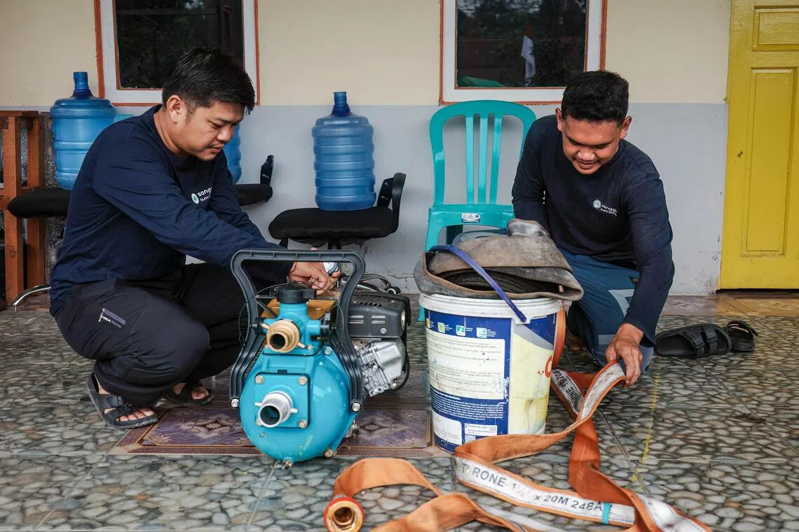 Sangga Bumi Lestari agricultural coordinator Kristoforus Sinyong (right) and restoration and regenerative agriculture staff member Hidayat prepare equipment to battle wildfires in Kapuas Hulu, West Kalimantan.