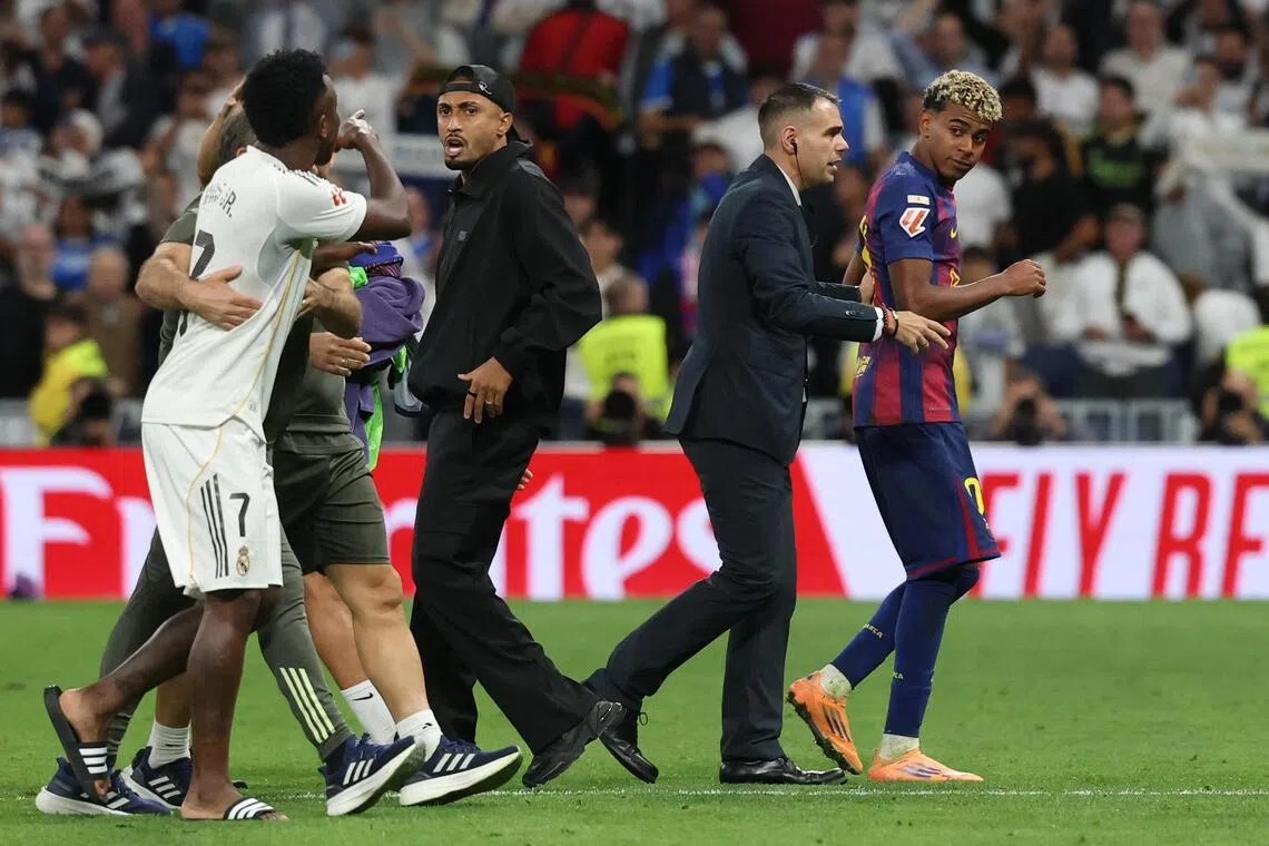 Real Madrid's Vinicius Junior argues with Barcelona's Lamine Yamal at the end of the match.