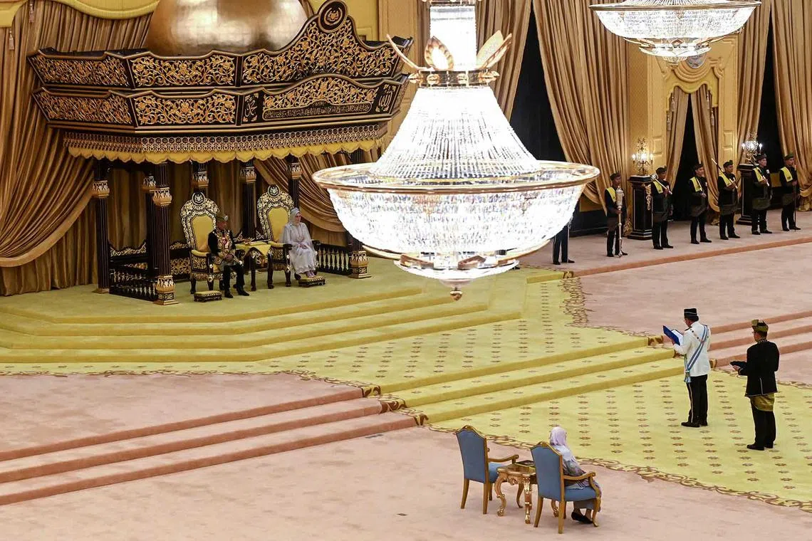 Malaysia's King Sultan Abdullah Sultan Ahmad Shah (left) and Queen Tunku Azizah Aminah Maimunah (second from left) sitting on the throne as Malaysia's Prime Minister Anwar Ibrahim (bottom, second from right) reads documents during the king's birthday celebrations at the National Palace in Kuala Lumpur, June 5.