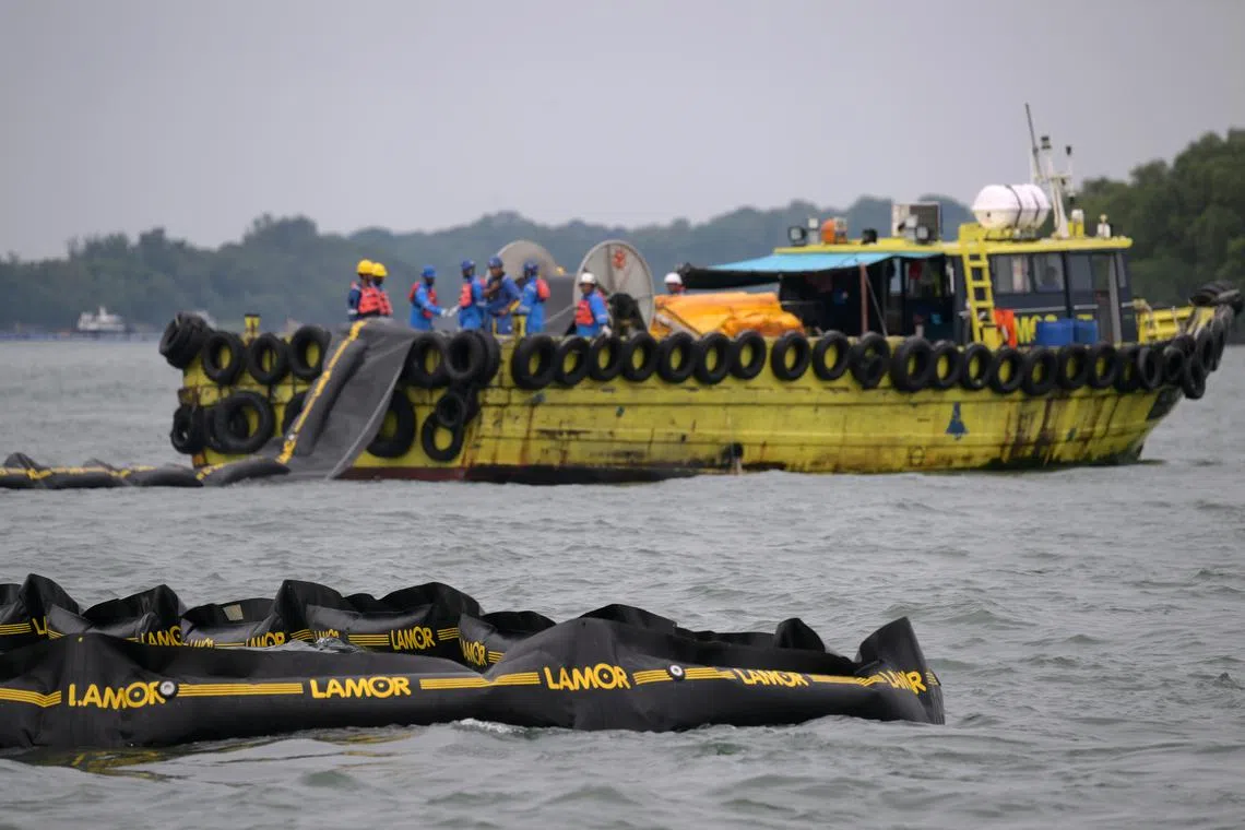Curtain booms being lowered into the sea off Siloso Beach in Sentosa on June 21.