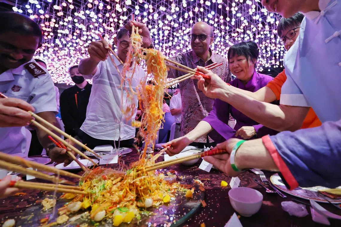 President Tharman Shanmugaratnam and his wife Ms Jane Ittogi participate in a lohei during the Gardens by the Bay community reunion dinner on Feb 22, 2024.