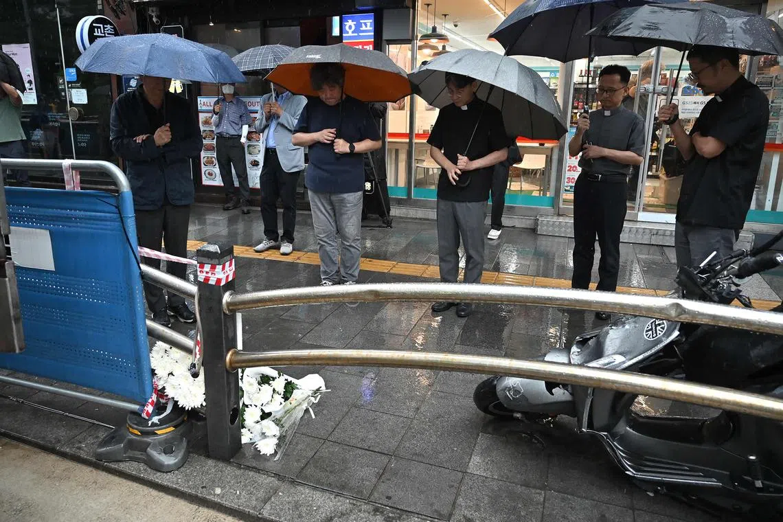 Priests pray for the victims at the site of the car accident which left nine dead.