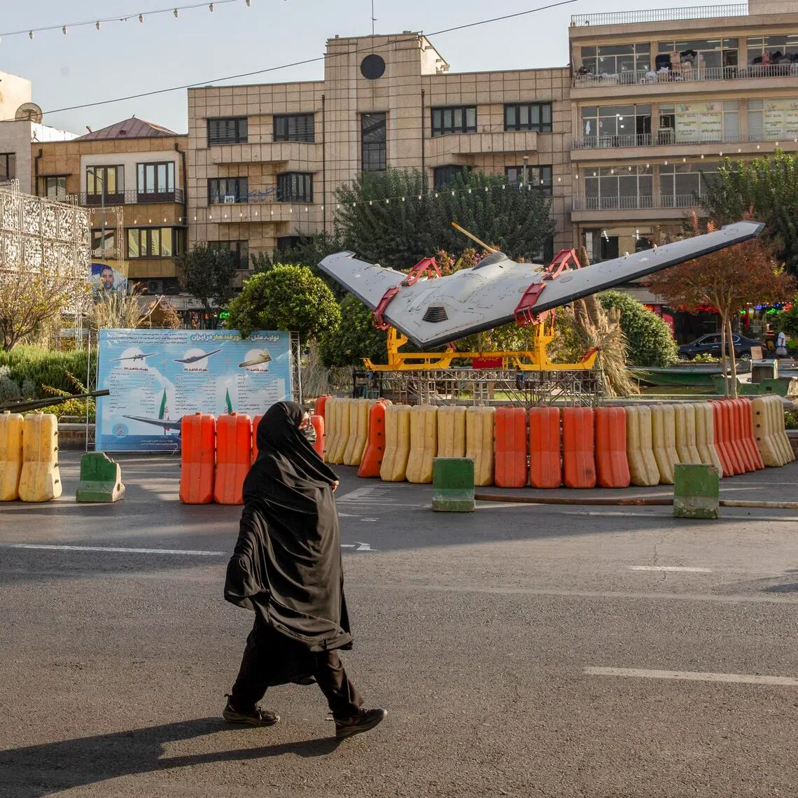 A woman walks past an Iranian Shahed drone variant displayed at a military exhibit in Tehran, Iran, on Oct 1, 2025. Iran has launched waves of Shahed drones to menace Persian Gulf nations.