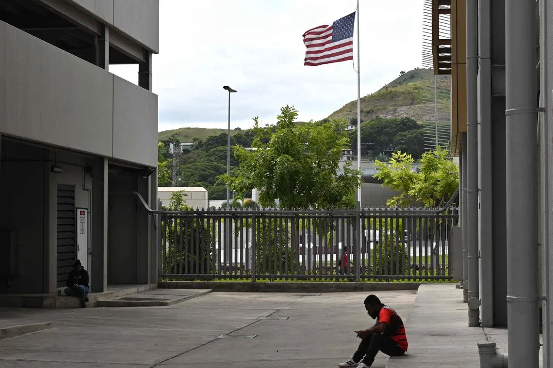 A man sits in front of the US embassy in Port Moresby on May 19, 2023. (Photo by ADEK BERRY / AFP)