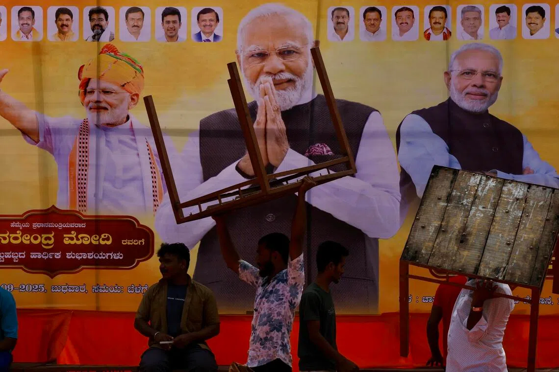 epa12384666 People in front of the billboard during Indian Prime Minister Narendra Modi's birthday celebrations in Bangalore, India, 17 September 2025. Bharatiya Janata Party (BJP)-led Indian Prime Minister Narendra Modi is celebrating his 75th birthday; he was born on 17 September 1950 in Vadnagar, Mehsana district, a small town in North Gujarat.  EPA/JAGADEESH NV