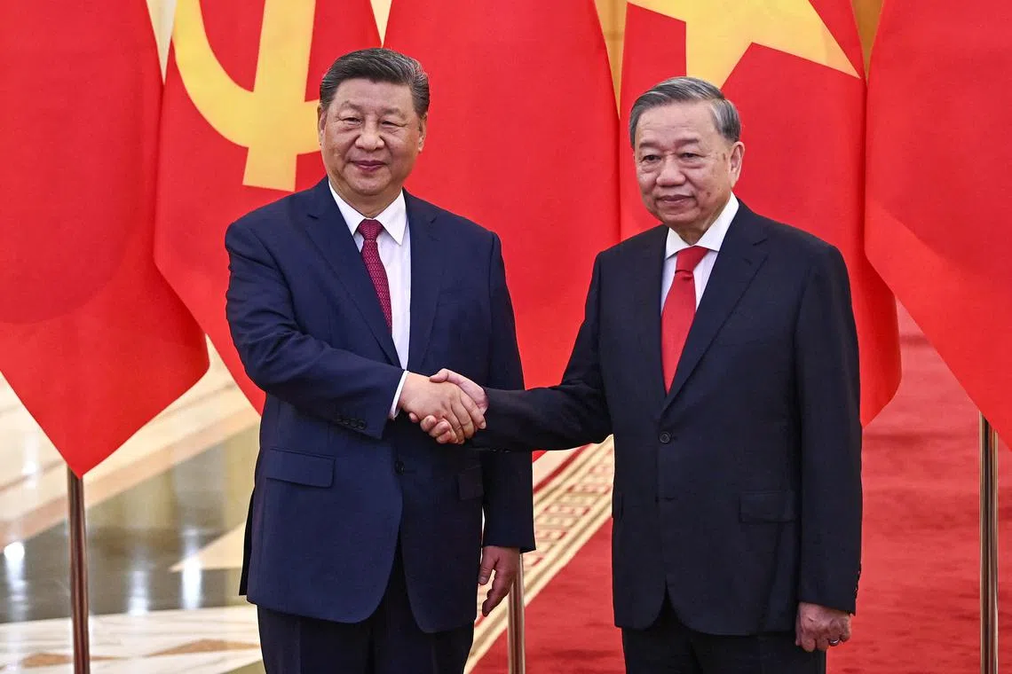 Chinese President Xi Jinping (left)  shakes hands with his Vietnamese counterpart To Lam at the Office of the Party Central Committee in Hanoi, on April 14.